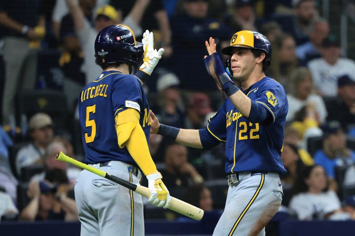 Oct 26, 2026; St. Petersburg, Florida, USA;  Milwaukee Brewers designated hitter Christian Yelich (22) celebrates with outfielder Garrett Mitchell (5) after scoring on a two-RBI infield single hit by infielder Brice Turang (not pictured) against Tampa Bay Rays pitcher Cam Booser (not pictured) during the fifth inning in game three of the 2026 World Series at Tropicana Field.  Mandatory Credit: Kim Klement Neitzel-Imagn Images