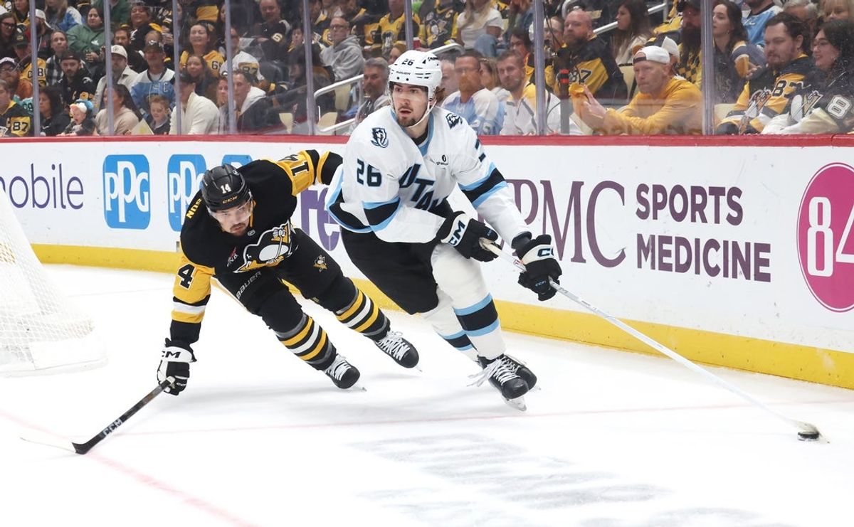 Oct 29, 2026; Pittsburgh, Pennsylvania, USA;  Utah Mammoth defenseman Dmitri Simashev (26) moves the puck against Pittsburgh Penguins left wing Nick Robertson (14) during the first period at PPG Paints Arena.  Mandatory Credit: Charles LeClaire-Imagn Images