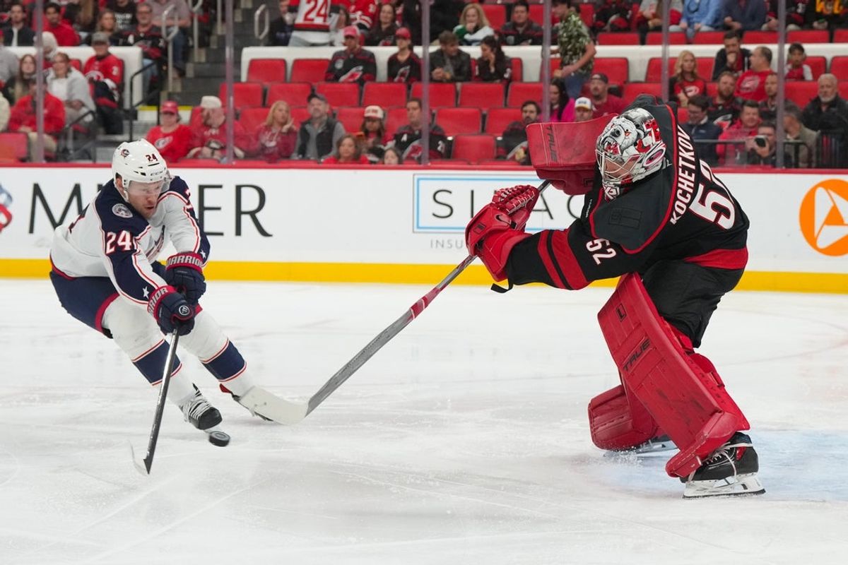 Oct 29, 2026; Raleigh, North Carolina, USA;  Carolina Hurricanes goaltender Pyotr Kochetkov (52) clears the puck away from Columbus Blue Jackets right wing Mathieu Olivier (24) during the second period at Lenovo Center.  Mandatory Credit: James Guillory-Imagn Images
