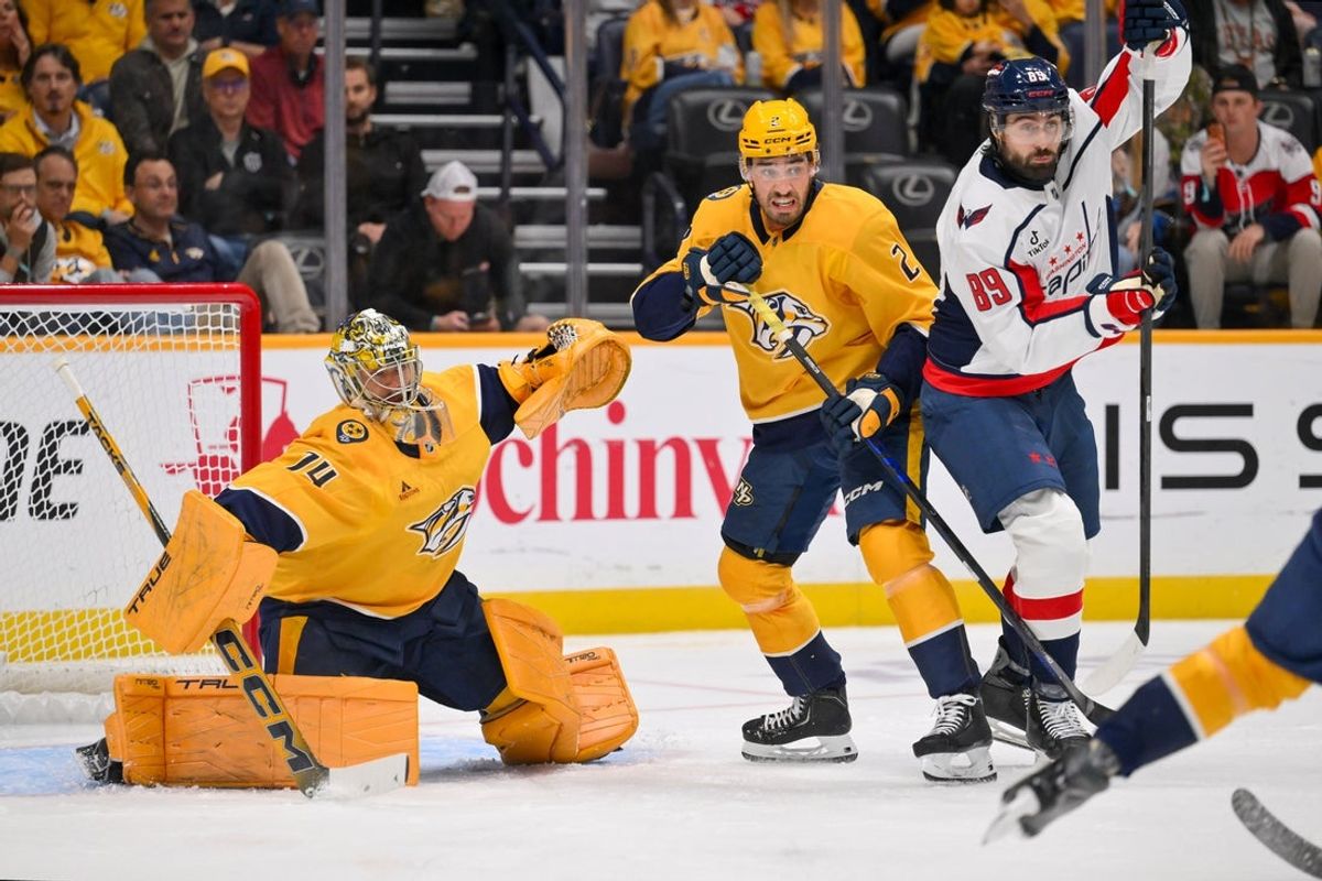 Oct 29, 2026; Nashville, Tennessee, USA;  Nashville Predators goaltender Juuse Saros (74) blocks the puck as Nashville Predators defenseman Adam Wilsby (2) and Washington Capitals right wing Alex Tuch (89) fight for position during the first period at Bridgestone Arena.  Mandatory Credit: Steve Roberts-Imagn Images