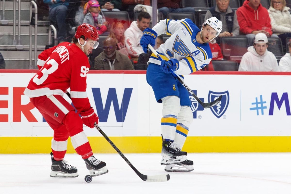 Oct 31, 2026; Detroit, Michigan, USA;  St. Louis Blues defenseman Philip Broberg (6) takes a shot defended by Detroit Red Wings right wing Alex DeBrincat (93) in the first period at Little Caesars Arena.  Mandatory Credit: Rick Osentoski-Imagn Images