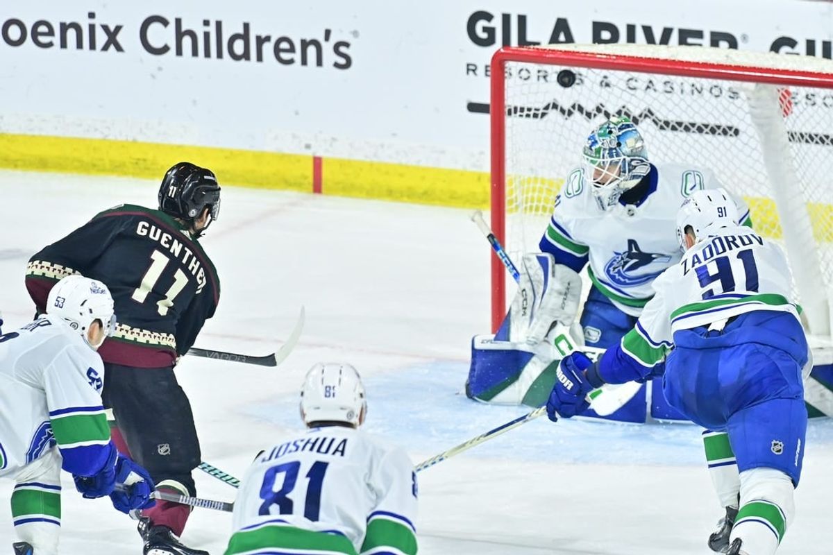 Apr 3, 2024; Tempe, Arizona, USA; Arizona Coyotes right wing Dylan Guenther (11) scores on Vancouver Canucks goaltender Arturs Silovs (31) inthe third period at Mullett Arena.