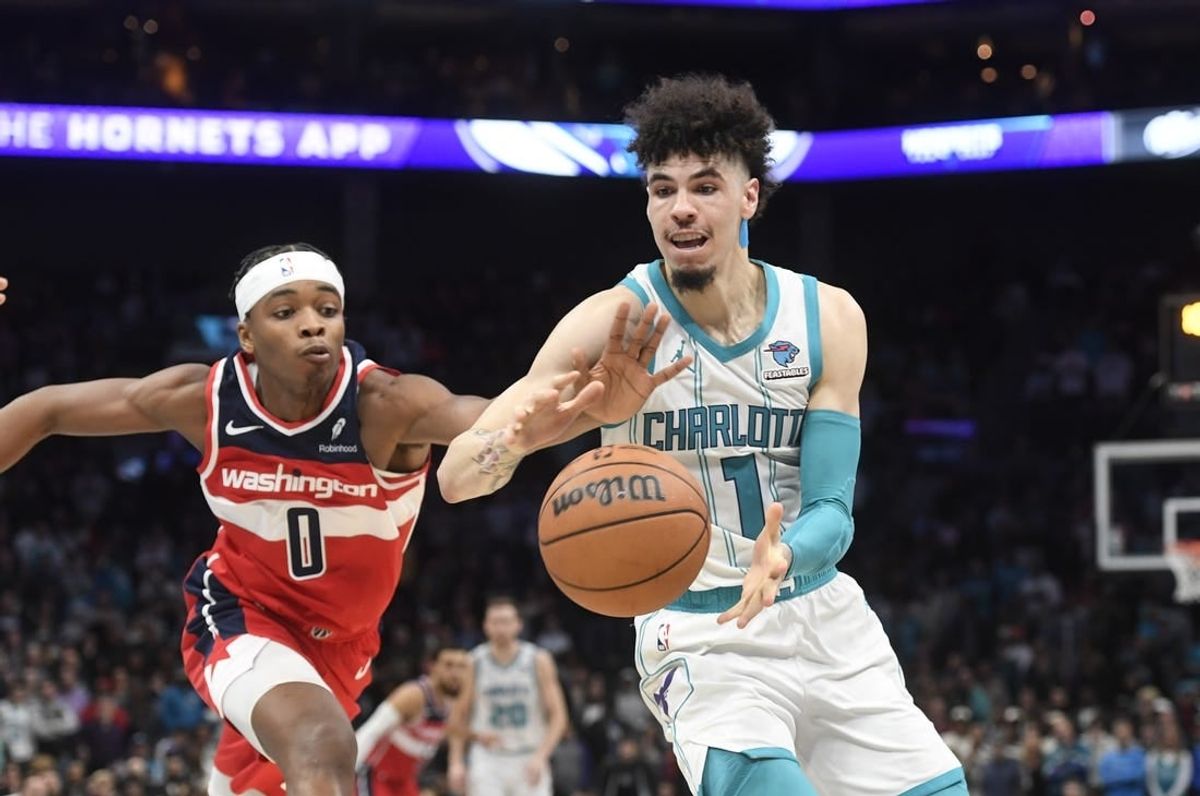 Nov 22, 2023; Charlotte, North Carolina, USA; Charlotte Hornets guard LaMelo Ball (1) catches a pass as Washington Wizards guard Bilal Coulibaly (0) attempts to steal during the second half at the Spectrum Center.