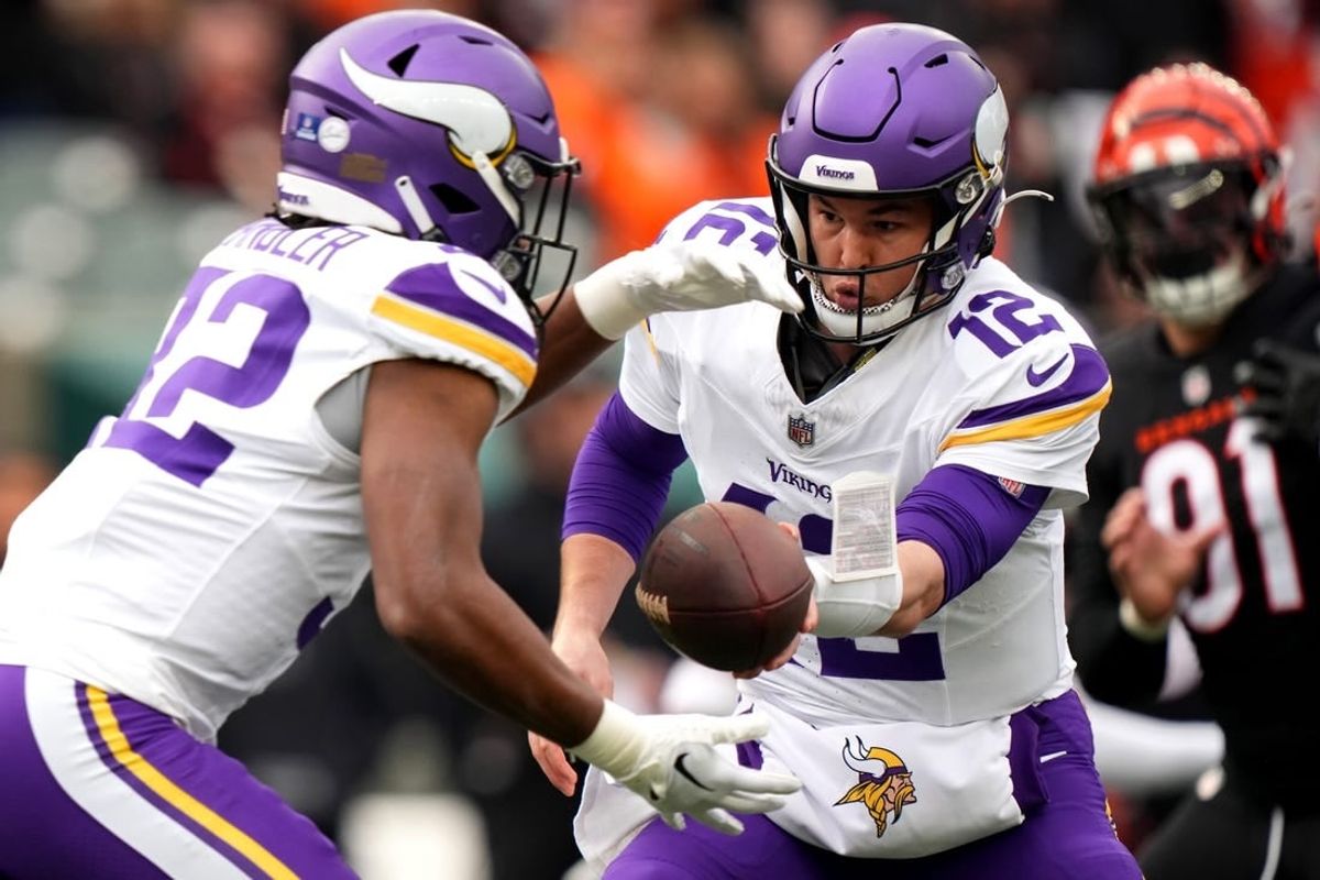 Dec 16, 2023; Cincinnati, Ohio, USA; Minnesota Vikings quarterback Nick Mullens (12) hands the ball off to Minnesota Vikings running back Ty Chandler (32) in the first quarter of the game against the Cincinnati Bengals at Paycor Stadium.