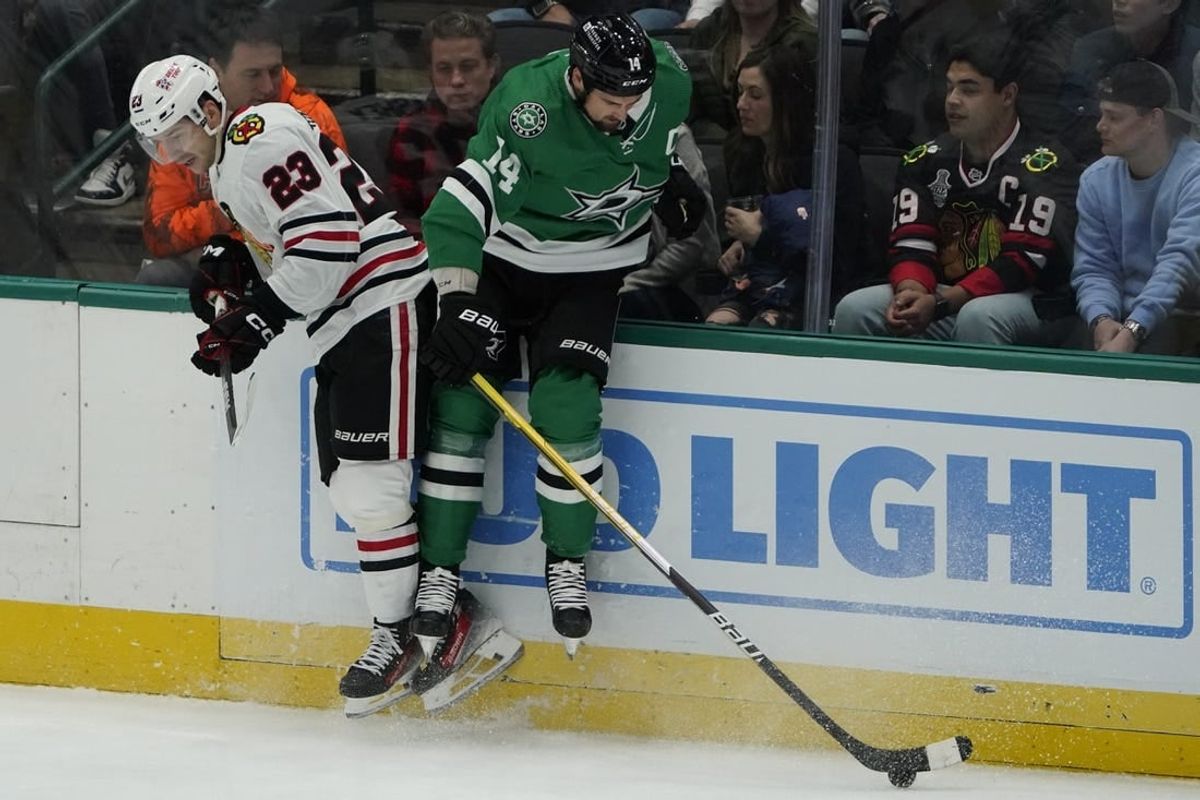 Dec 29, 2023; Dallas, Texas, USA; Chicago Blackhawks center Philipp Kurashev (23) takes Dallas Stars left wing Jamie Benn (14) off the puck during the first period at American Airlines Center.