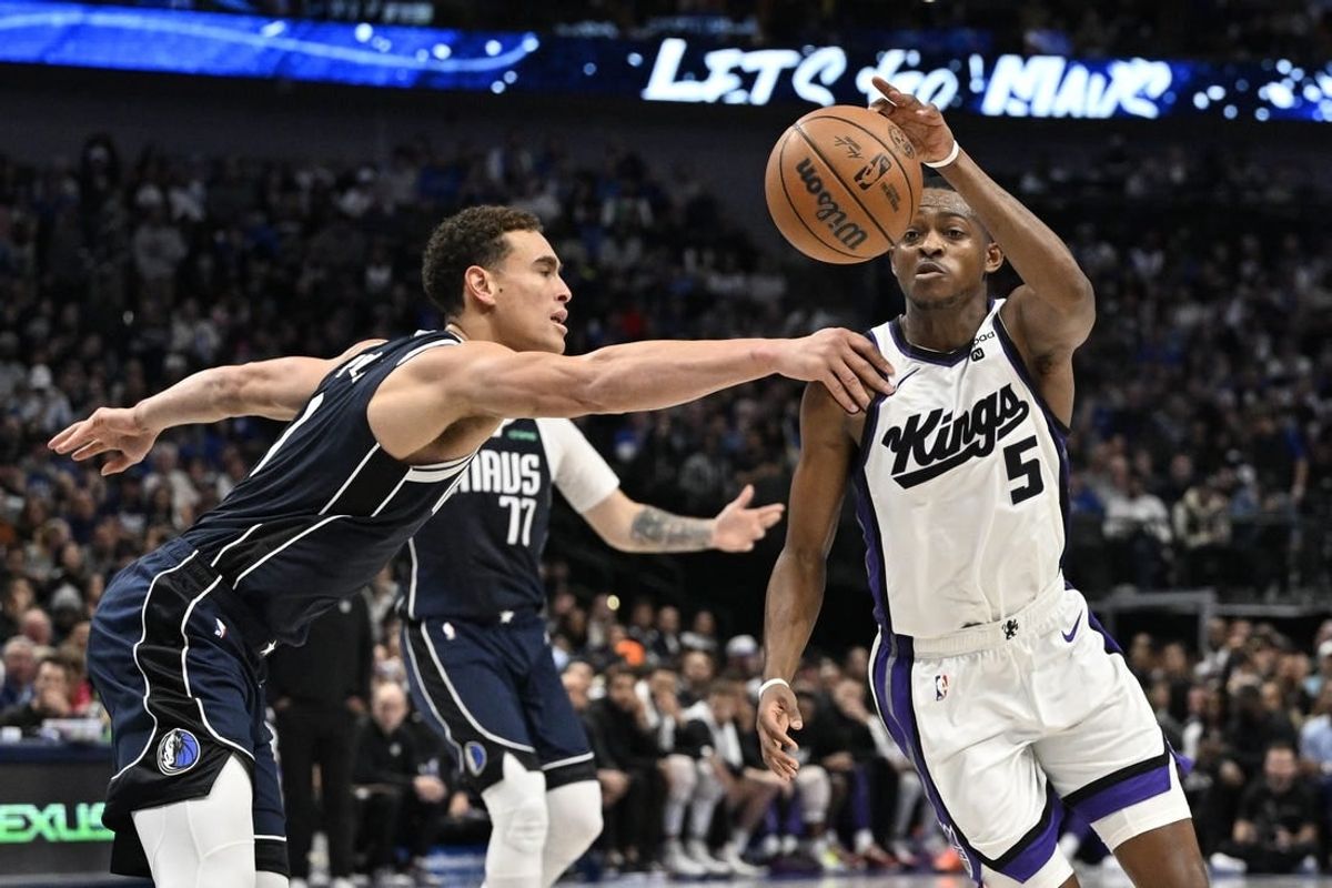 Nov 19, 2023; Dallas, Texas, USA;Dallas Mavericks center Dwight Powell (7) and Sacramento Kings guard De'Aaron Fox (5) battle for control of a loose ball during the second quarter at the American Airlines Center.