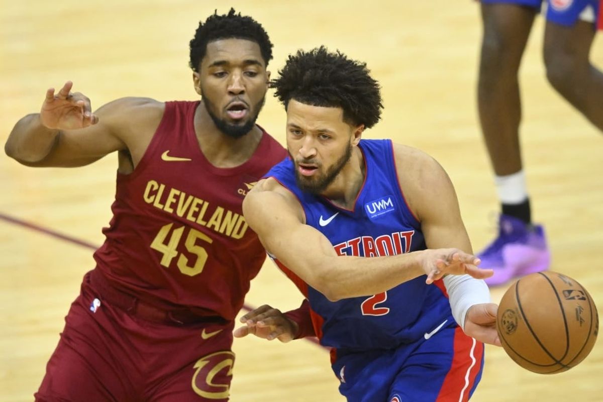 Jan 31, 2024; Cleveland, Ohio, USA; Detroit Pistons guard Cade Cunningham (2) throws a pass beside Cleveland Cavaliers guard Donovan Mitchell (45) in the fourth quarter at Rocket Mortgage FieldHouse.