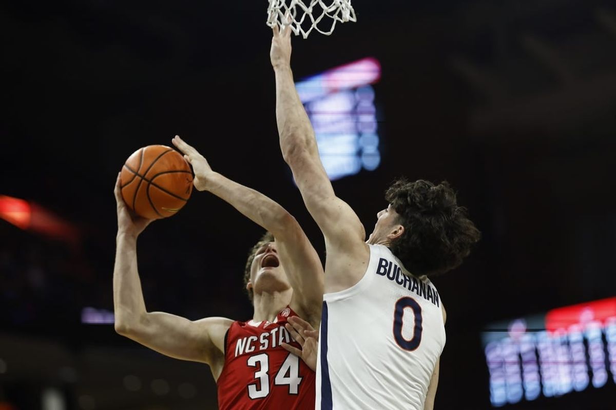 Jan 24, 2024; Charlottesville, Virginia, USA; North Carolina State Wolfpack forward Ben Middlebrooks (34) shoots the ball as Virginia Cavaliers forward Blake Buchanan (0) defends in the first half at John Paul Jones Arena.