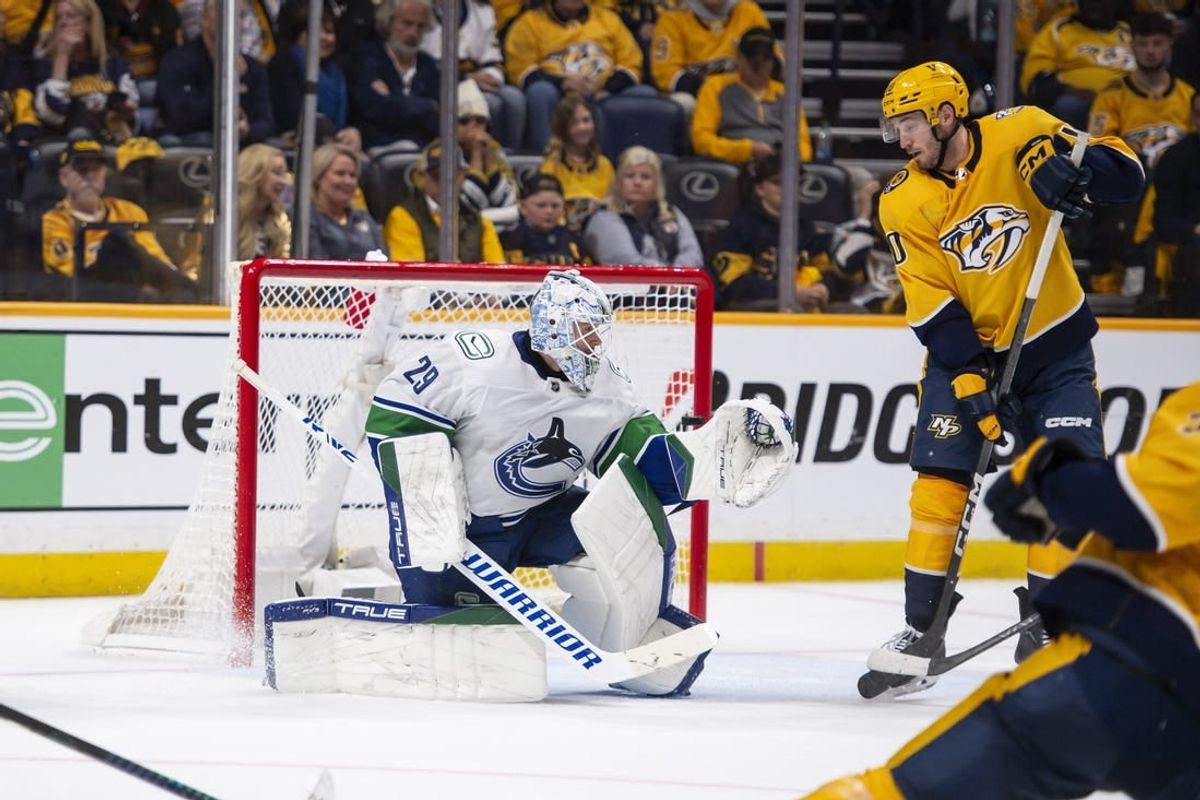Apr 26, 2024; Nashville, Tennessee, USA; Nashville Predators right wing Luke Evangelista (77) scores past Vancouver Canucks goaltender Casey DeSmith (29) during the third period in game three of the first round of the 2024 Stanley Cup Playoffs at Bridgestone Arena.