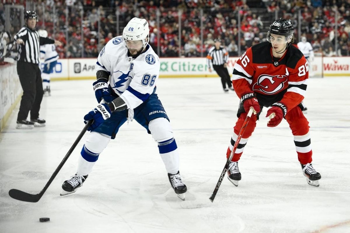 Feb 25, 2024; Newark, New Jersey, USA; Tampa Bay Lightning right wing Nikita Kucherov (86) skates with the puck while being defended by New Jersey Devils center Jack Hughes (86) during the first period at Prudential Center.