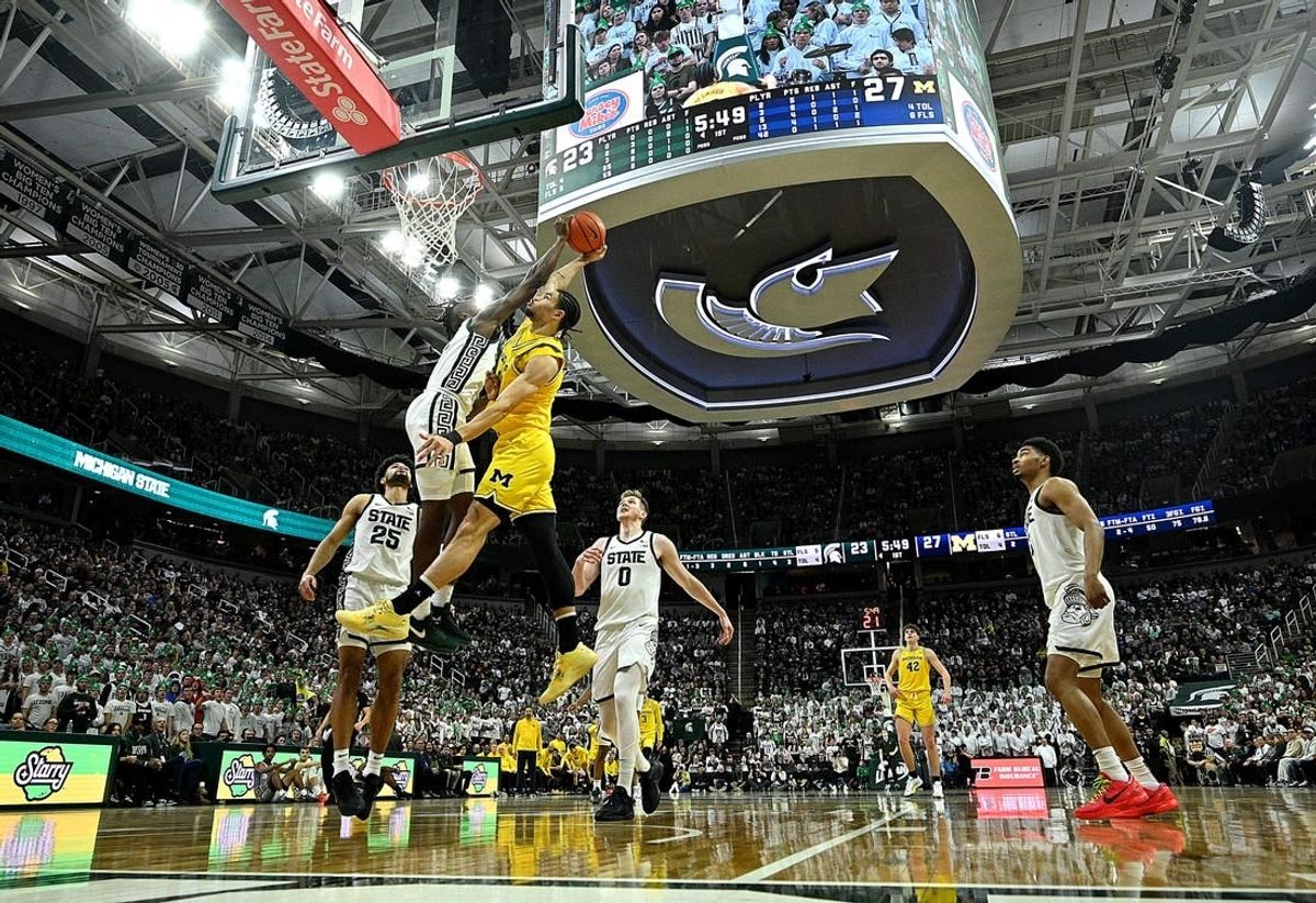 Jan 30, 2024; East Lansing, Michigan, USA; Michigan Wolverines forward Olivier Nkamhoua (13) gets blocked by Michigan State Spartans forward Coen Carr (55) during the first half at Jack Breslin Student Events Center.