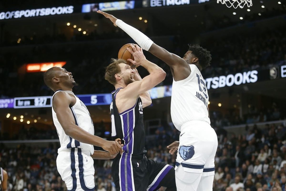 Dec 31, 2023; Memphis, Tennessee, USA; Sacramento Kings forward Domantas Sabonis (10) drives to the basket between Memphis Grizzlies center Bismack Biyombo (18) and forward-center Jaren Jackson Jr. (13) during the first half at FedExForum.