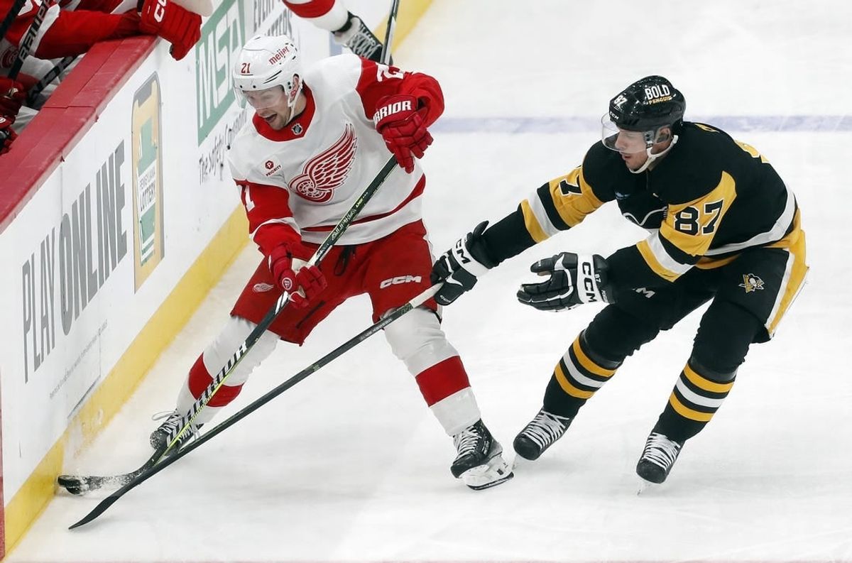 Mar 17, 2024; Pittsburgh, Pennsylvania, USA;  Detroit Red Wings center Austin Czarnik (21) moves the puck against Pittsburgh Penguins center Sidney Crosby (87) during the third period at PPG Paints Arena. Pittsburgh won 6-3.