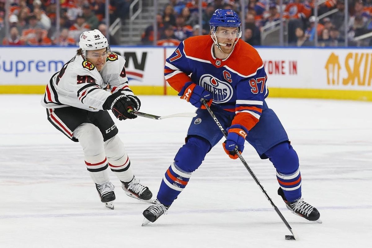 Dec 12, 2023; Edmonton, Alberta, CAN; Chicago Blackhawks forward Connor Bedard (98) tries to knock the puck away from Edmonton Oilers forward Connor McDavid (97) during the first period at Rogers Place.