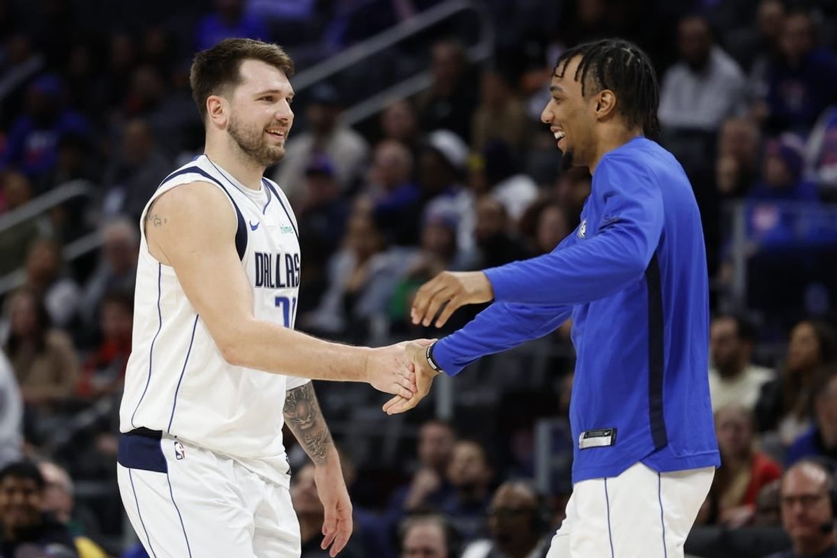 Mar 9, 2024; Detroit, Michigan, USA;  Dallas Mavericks guard Luka Doncic (77) receives congratulations from guard A.J. Lawson (9) in the second half against the Detroit Pistons at Little Caesars Arena.