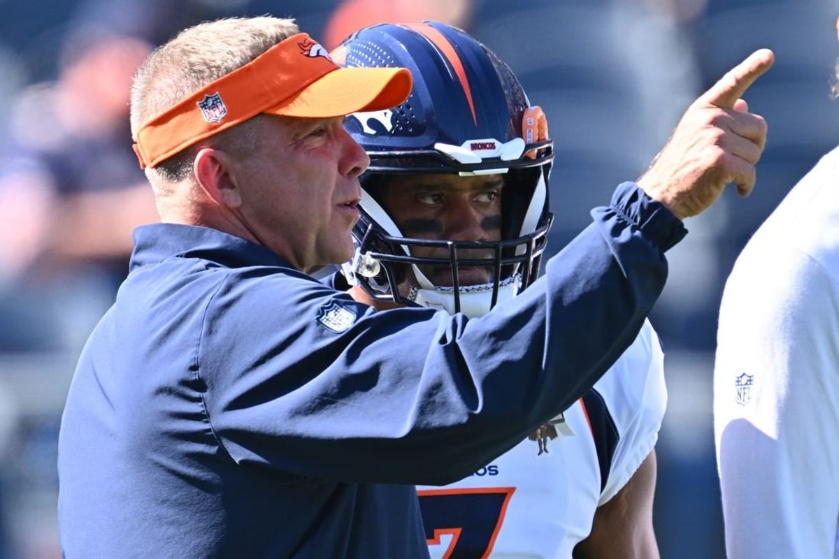 Oct 1, 2023; Chicago, Illinois, USA;  Denver Broncos head coach Sean Payton talks with quarterback Russell Wilson (3) before a game against the Chicago Bears at Soldier Field.
