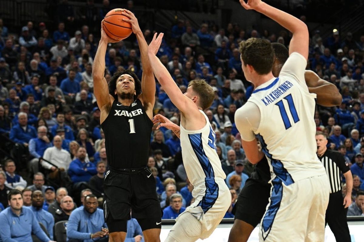 Jan 23, 2024; Omaha, Nebraska, USA;  Xavier Musketeers guard Desmond Claude (1) scores over Creighton Bluejays guard Baylor Scheierman (55) in the first half at CHI Health Center Omaha.