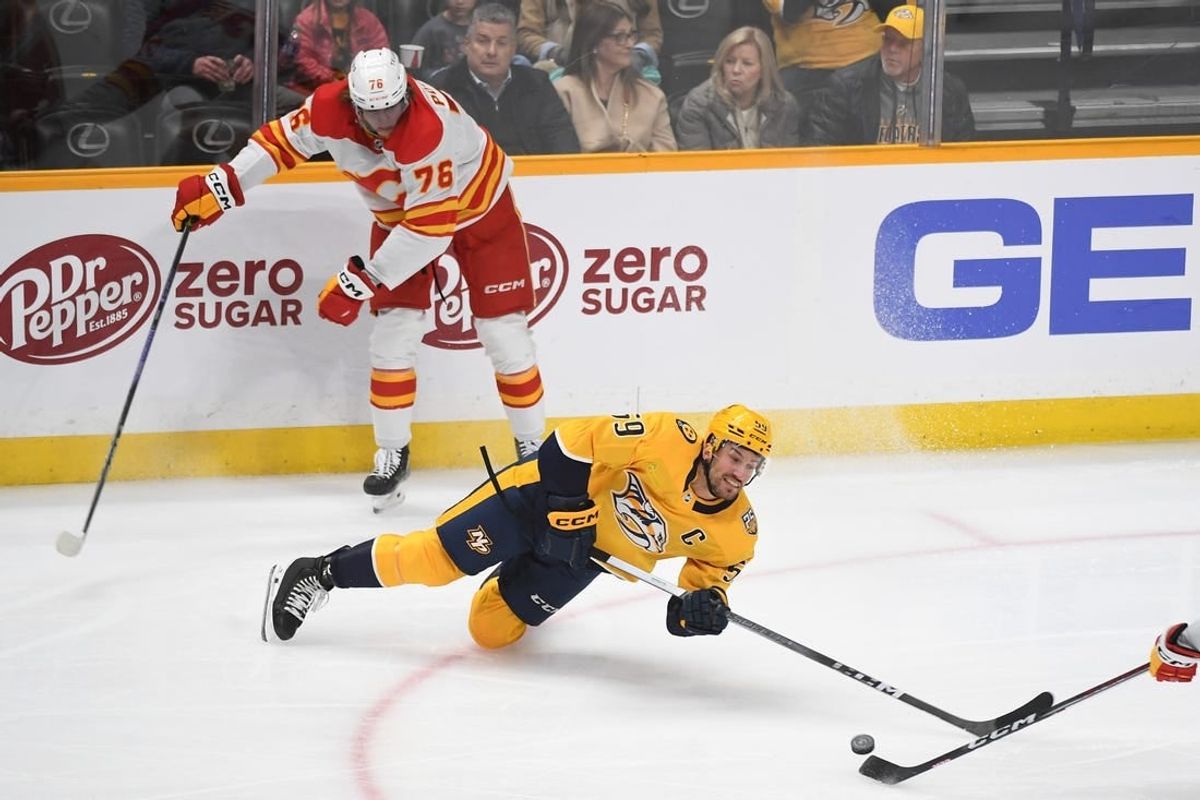 Jan 4, 2024; Nashville, Tennessee, USA; Nashville Predators defenseman Roman Josi (59) loses the puck as he falls to the ice after a hit by Calgary Flames center Martin Pospisil (76) during the first period at Bridgestone Arena.
