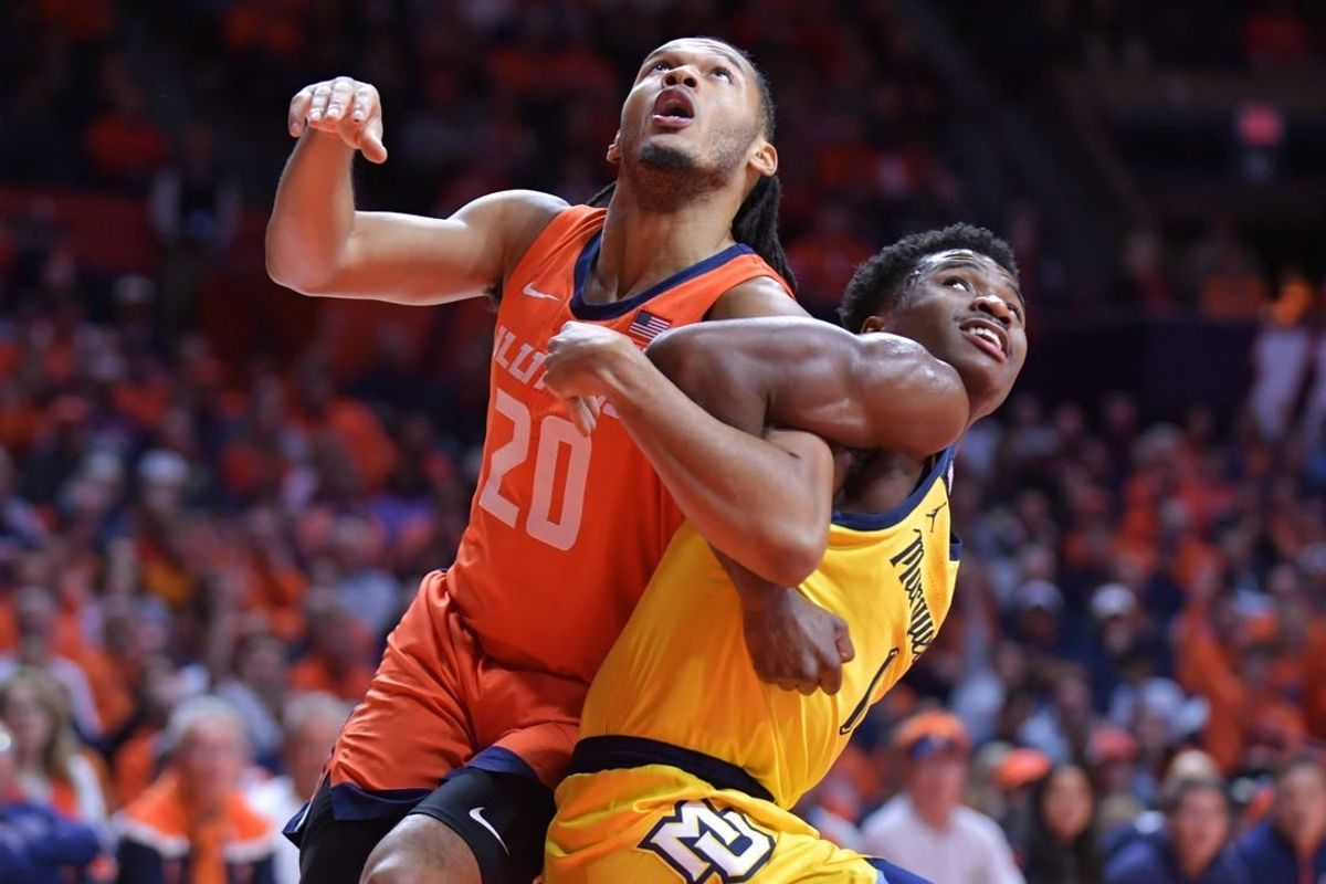 Nov 14, 2023; Champaign, Illinois, USA; Illinois Fighting Illini forward Ty Rodgers (20) and Marquette Golden Eagles guard Kam Jones (1) battle for position during the first half at State Farm Center.