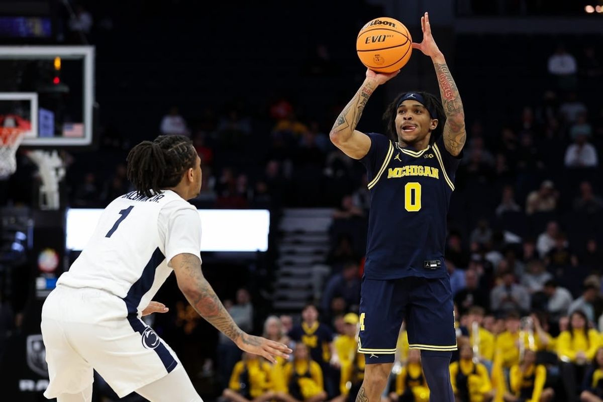 Mar 13, 2024; Minneapolis, MN, USA; Michigan Wolverines guard Dug McDaniel (0) shoots as Penn State Nittany Lions guard Ace Baldwin Jr. (1) defends during the first half at Target Center.