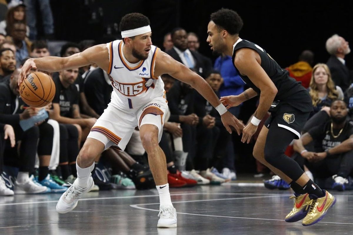Nov 24, 2023; Memphis, Tennessee, USA; Phoenix Suns guard Devin Booker (1) dribbles as Memphis Grizzlies guard Jacob Gilyard (0) defends during the second half at FedExForum.