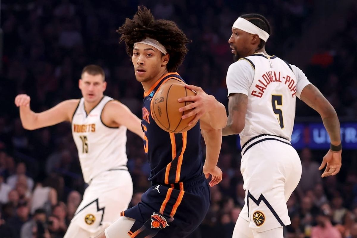 Jan 25, 2024; New York, New York, USA; New York Knicks center Jericho Sims (45) controls the ball against Denver Nuggets center Nikola Jokic (15) and guard Kentavious Caldwell-Pope (5) during the first quarter at Madison Square Garden.