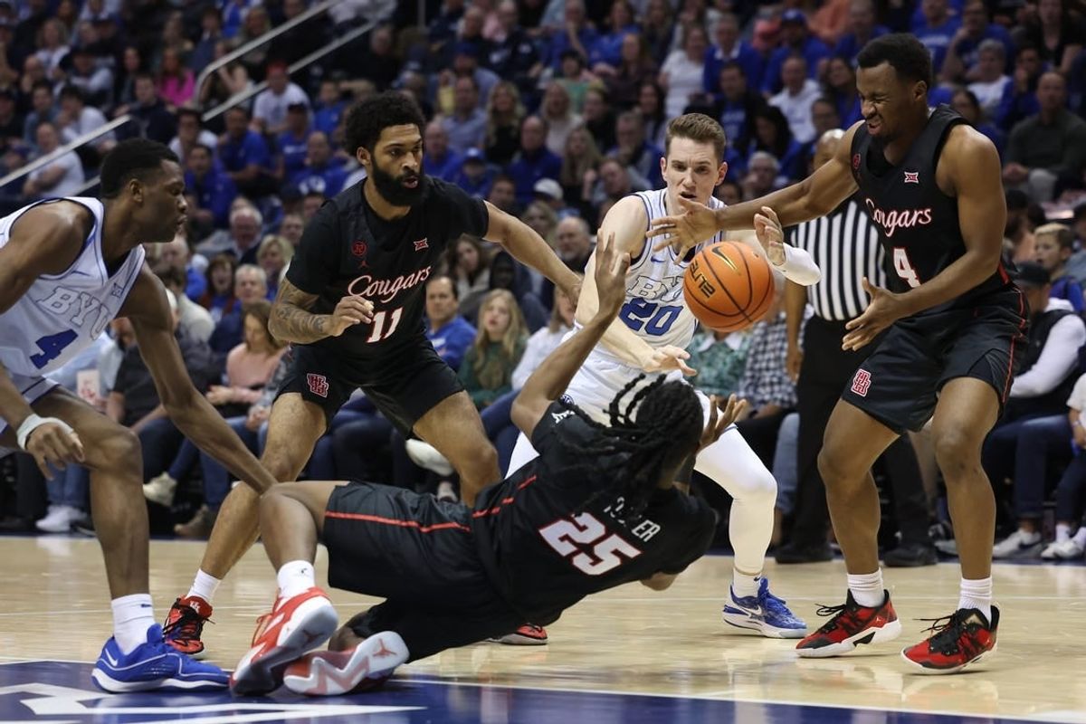 Jan 23, 2024; Provo, Utah, USA; Houston Cougars forward Joseph Tugler (25) passes the ball to guard L.J. Cryer (4) defended by Brigham Young Cougars guard Spencer Johnson (20) during the second half at Marriott Center.