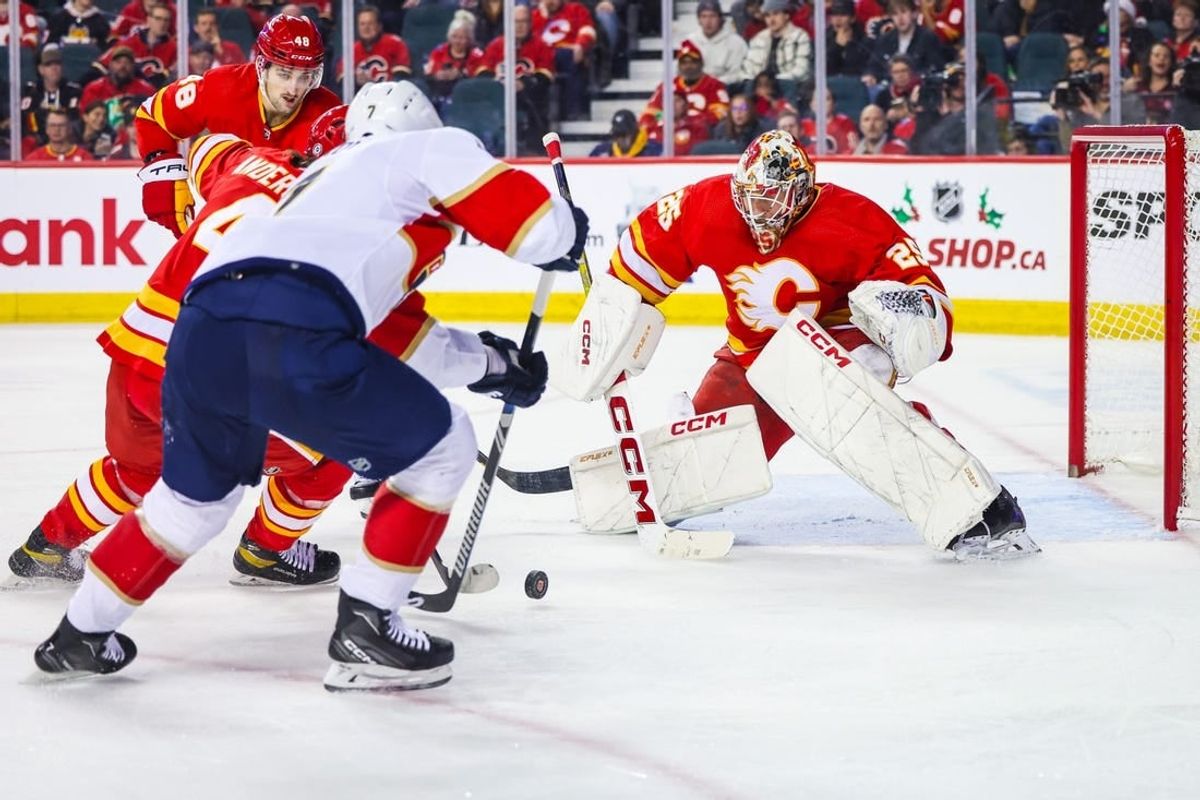 Dec 18, 2023; Calgary, Alberta, CAN; Calgary Flames goaltender Jacob Markstrom (25) makes a save against Florida Panthers defenseman Dmitry Kulikov (7) during the second period at Scotiabank Saddledome.