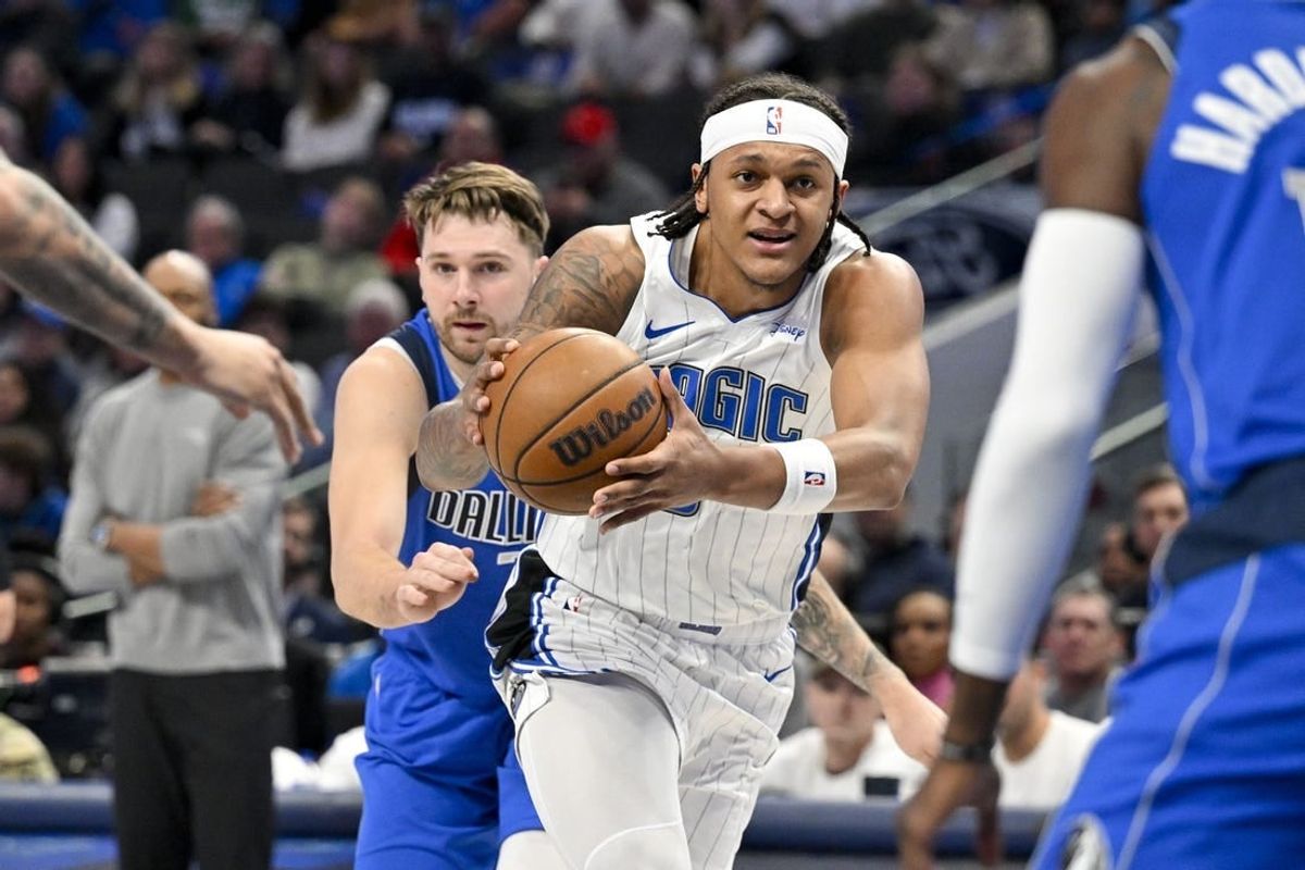Jan 29, 2024; Dallas, Texas, USA; Orlando Magic forward Paolo Banchero (5) drives to the basket past Dallas Mavericks guard Luka Doncic (77) during the first quarter at the American Airlines Center.