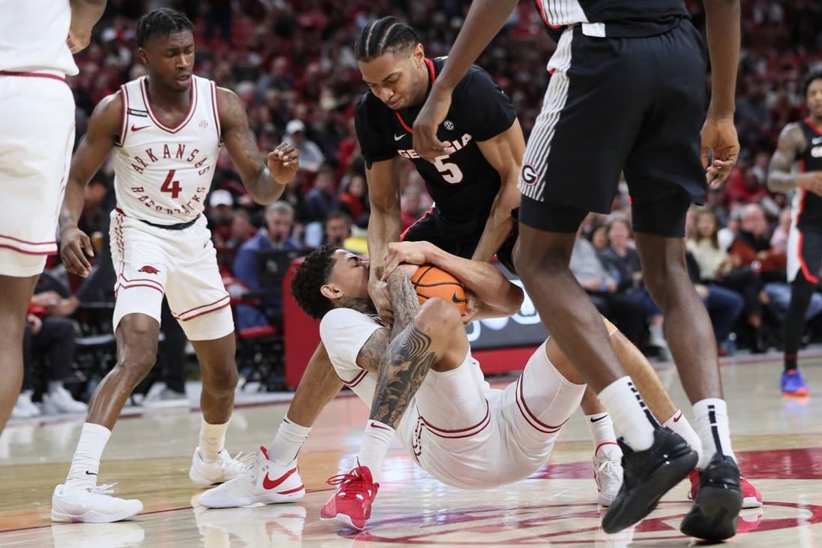 Feb 10, 2024; Fayetteville, Arkansas, USA; Arkansas Razorbacks forward Jalen Graham (11) and Georgia Bulldogs center Frank Anselem-Ibe (5) wrestle for possession during the first half at Bud Walton Arena.