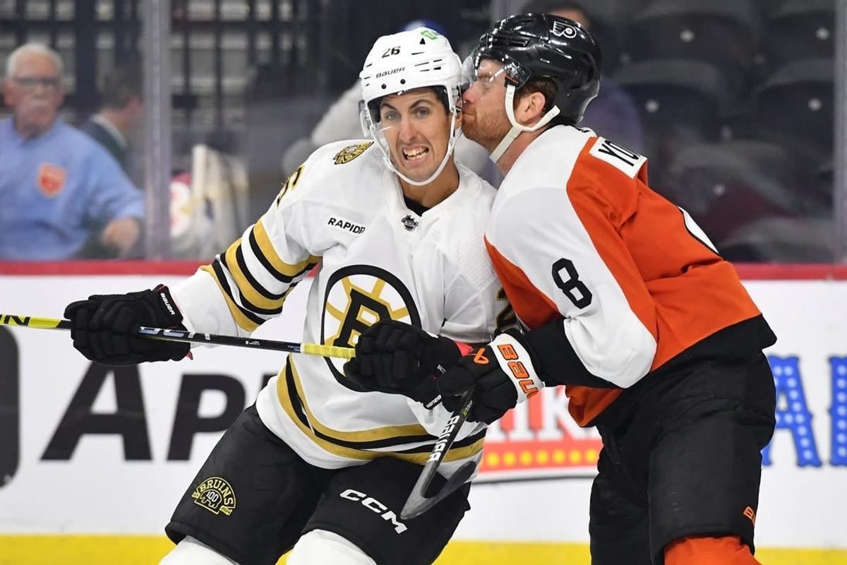 Oct 2, 2023; Philadelphia, Pennsylvania, USA; Boston Bruins center Marc McLaughlin (26) and Philadelphia Flyers defenseman Cam York (8) battle for position during the third period at Wells Fargo Center.