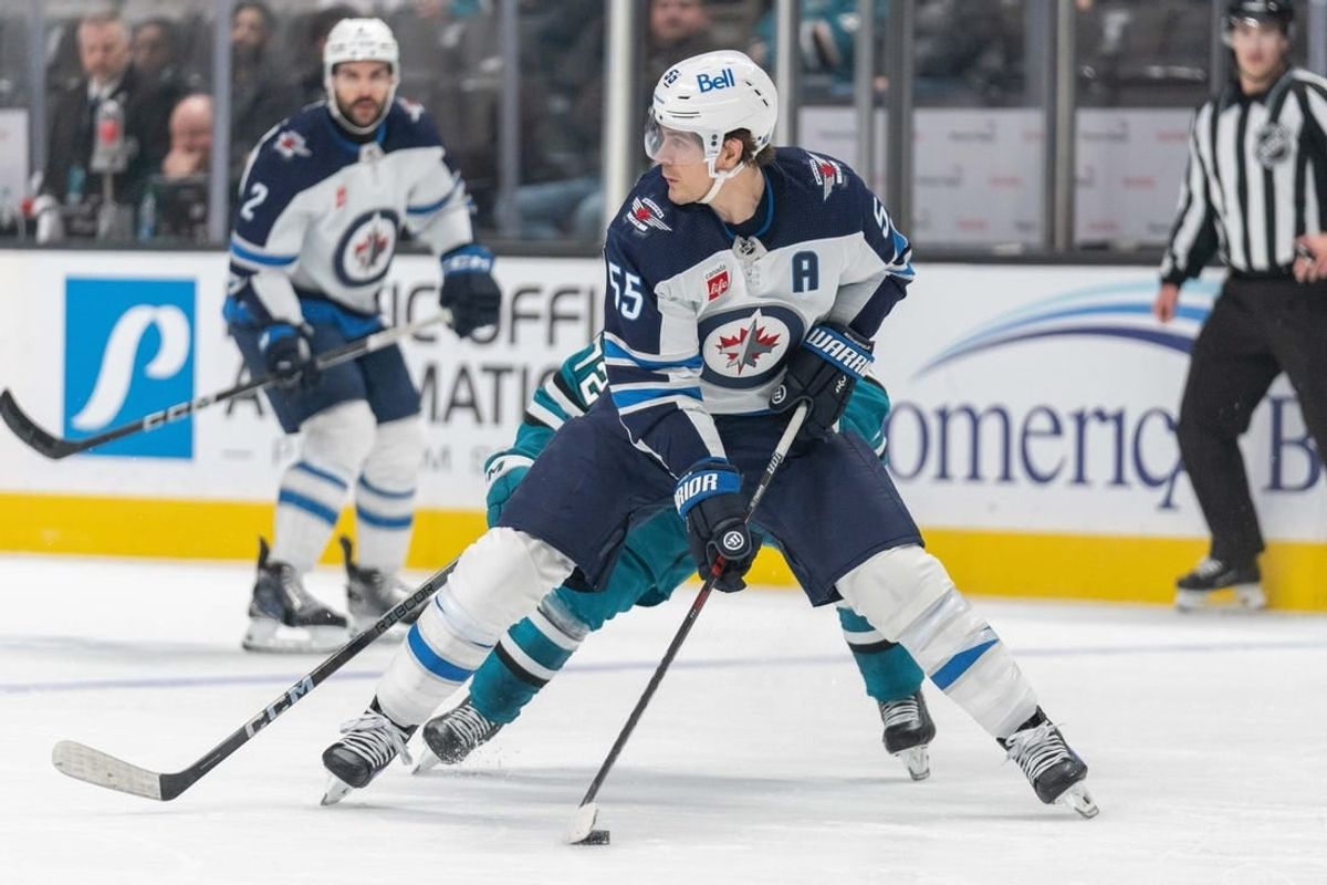 Jan 4, 2024; San Jose, California, USA;s Winnipeg Jets center Mark Scheifele (55) controls the puck during the second period against San Jose Sharks left wing William Eklund (72) at SAP Center at San Jose.