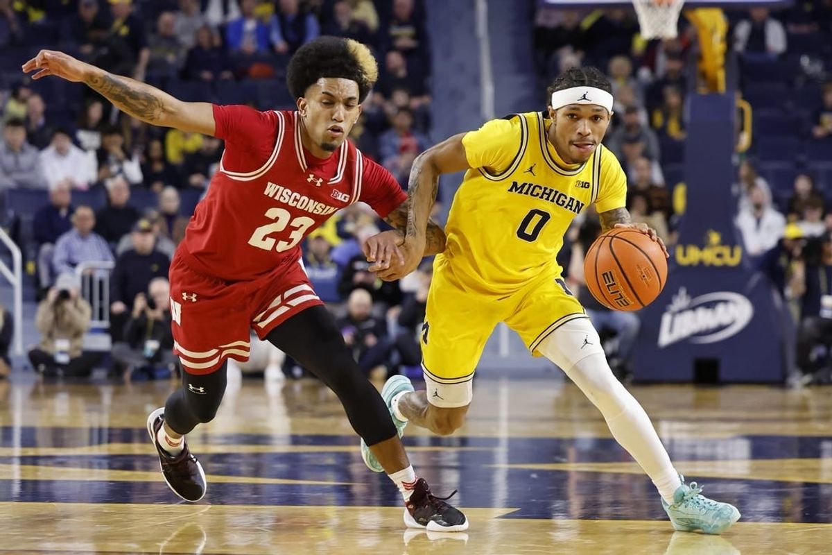 Feb 7, 2024; Ann Arbor, Michigan, USA;  Michigan Wolverines guard Dug McDaniel (0) dnr on Wisconsin Badgers guard Chucky Hepburn (23) in the first half at Crisler Center.