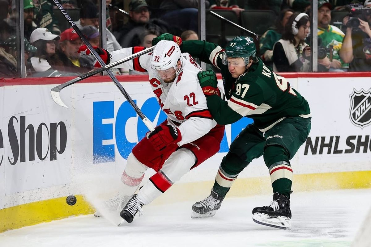 Feb 27, 2024; Saint Paul, Minnesota, USA; Carolina Hurricanes defenseman Brett Pesce (22) and Minnesota Wild left wing Kirill Kaprizov (97) compete for the puck during the second period at Xcel Energy Center.