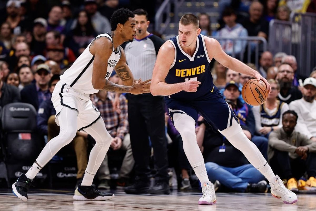 Dec 14, 2023; Denver, Colorado, USA; Denver Nuggets center Nikola Jokic (15) controls the ball as Brooklyn Nets center Nic Claxton (33) guards in the first quarter at Ball Arena.