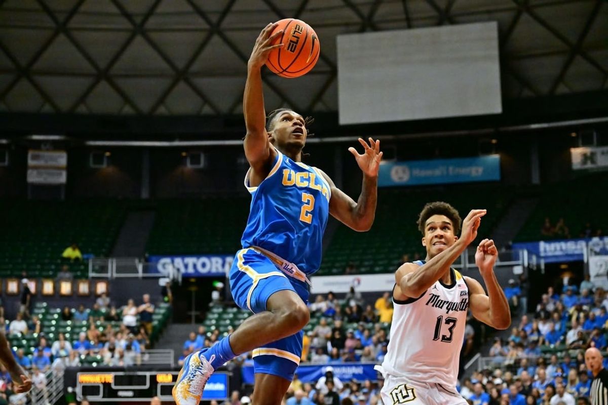 Nov 20, 2023; Honolulu, Hawaii, USA;  UCLA Bruins guard Dylan Andrews (2) drives to the basket against Marquette Golden Eagles forward Oso Ighodaro (13) during the first period at SimpliFi Arena at Stan Sheriff Center.