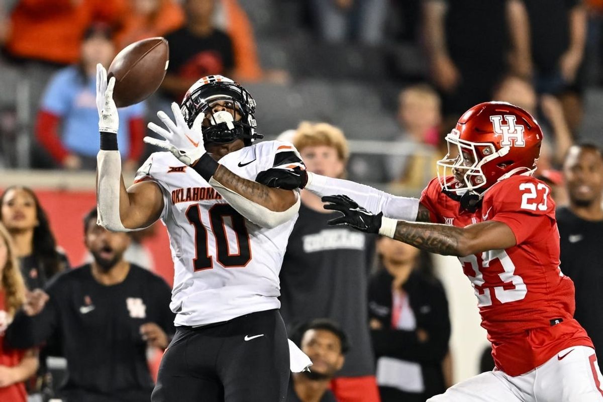 Nov 18, 2023; Houston, Texas, USA; Oklahoma State Cowboys wide receiver Rashod Owens (10) catches a pass during the fourth quarter as Houston Cougars defensive back Isaiah Hamilton (23) defends at TDECU Stadium.
