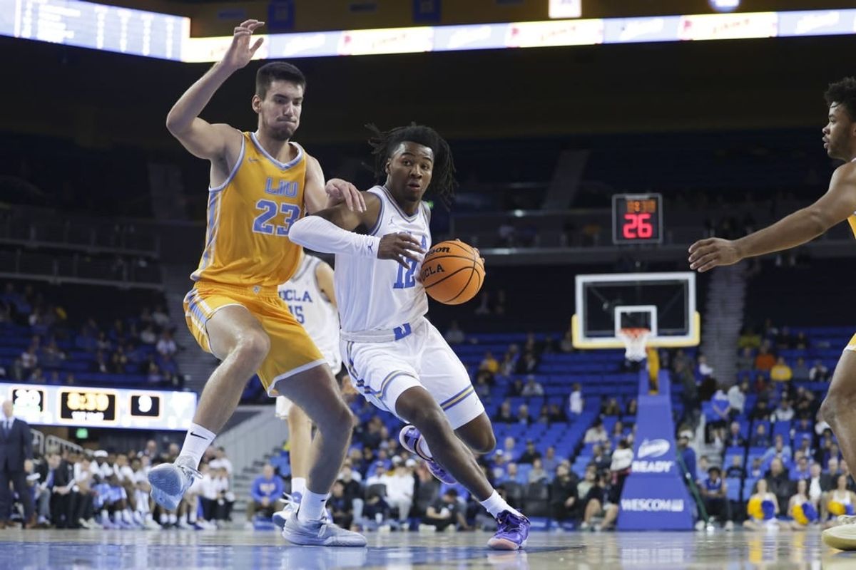 Nov 15, 2023; Los Angeles, California, USA; UCLA guard Sebastian Mack (12) drives the ball against Long Island University forward Nikola Djapa (23) during the first half at Pauley Pavilion presented by Wescom.