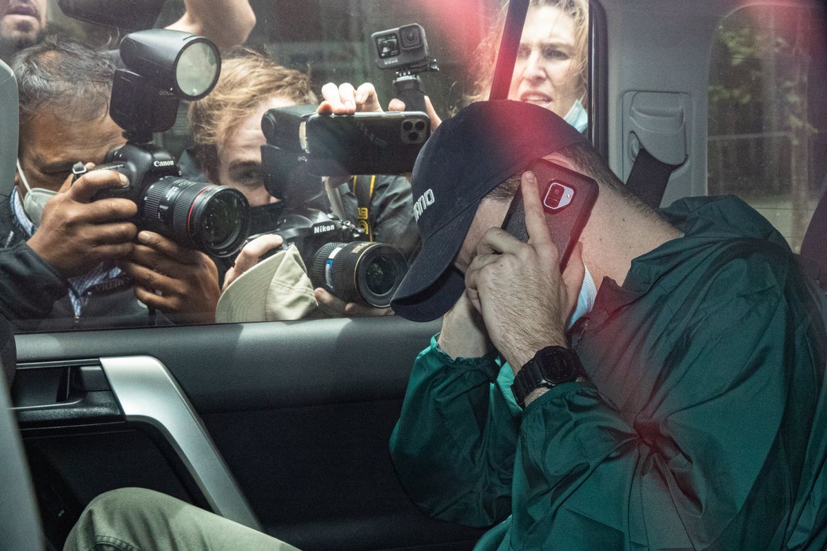 Novak Djokovic tries to duck a swarm of Australian press as he’s heaved out of the country.