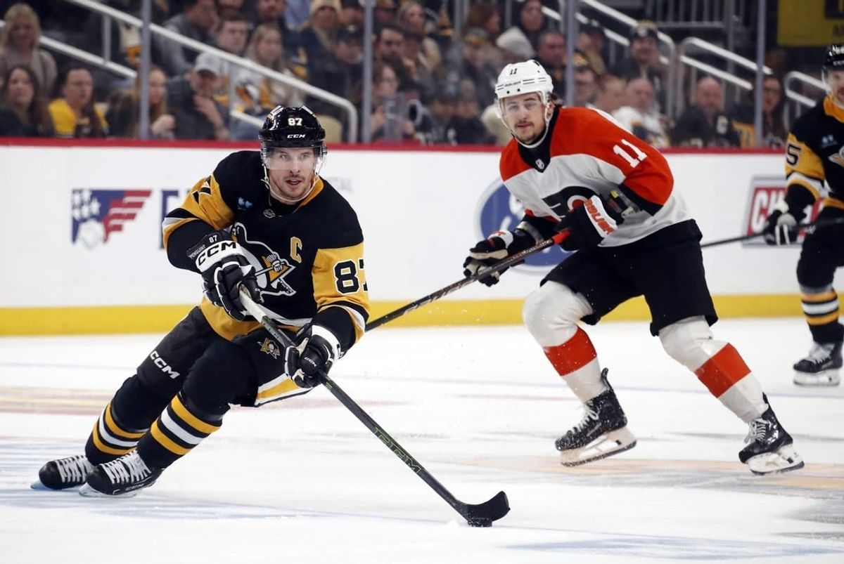Dec 2, 2023; Pittsburgh, Pennsylvania, USA; Pittsburgh Penguins center Sidney Crosby (87) skates up ice with the puck ahead of Philadelphia Flyers right wing Travis Konecny (11) during the third period at PPG Paints Arena. The Flyers won 4-3 in a shootout.