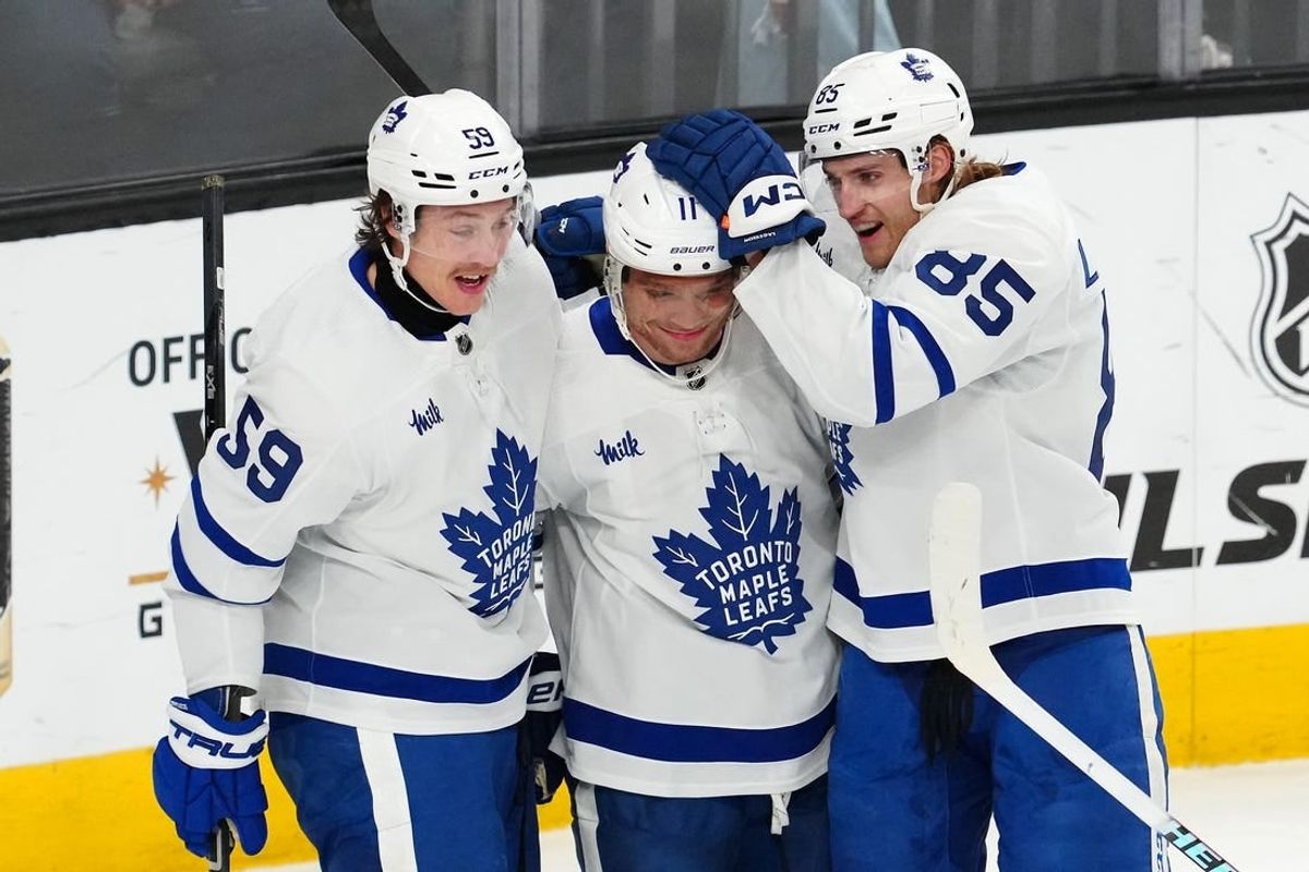 Feb 22, 2024; Las Vegas, Nevada, USA; Toronto Maple Leafs center Max Domi (11) celebrates with left wing Tyler Bertuzzi (59) and defenseman William Lagesson (85) after scoring a goal against the Vegas Golden Knights during the first period at T-Mobile Arena.