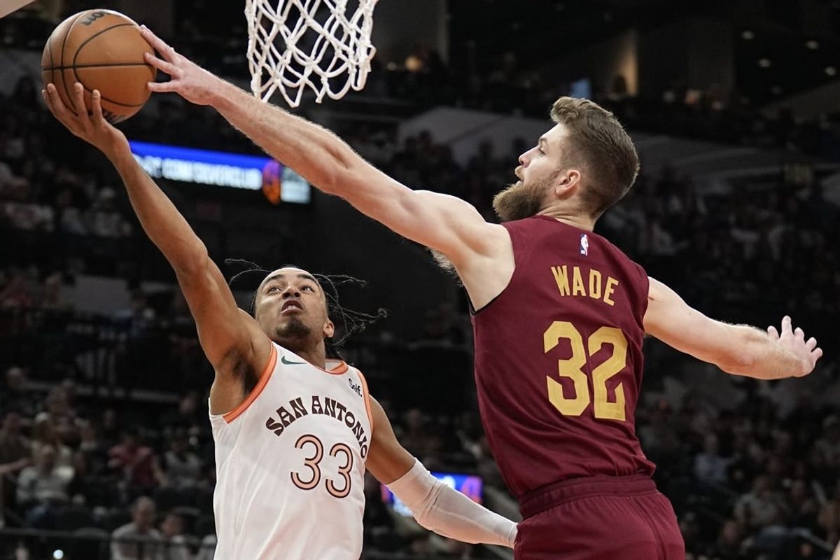 Feb 3, 2024; San Antonio, Texas, USA; Cleveland Cavaliers forward Dean Wade (32) blocks the shot attempted by San Antonio Spurs 33 guard Tre Jones (33) during the first half at Frost Bank Center.