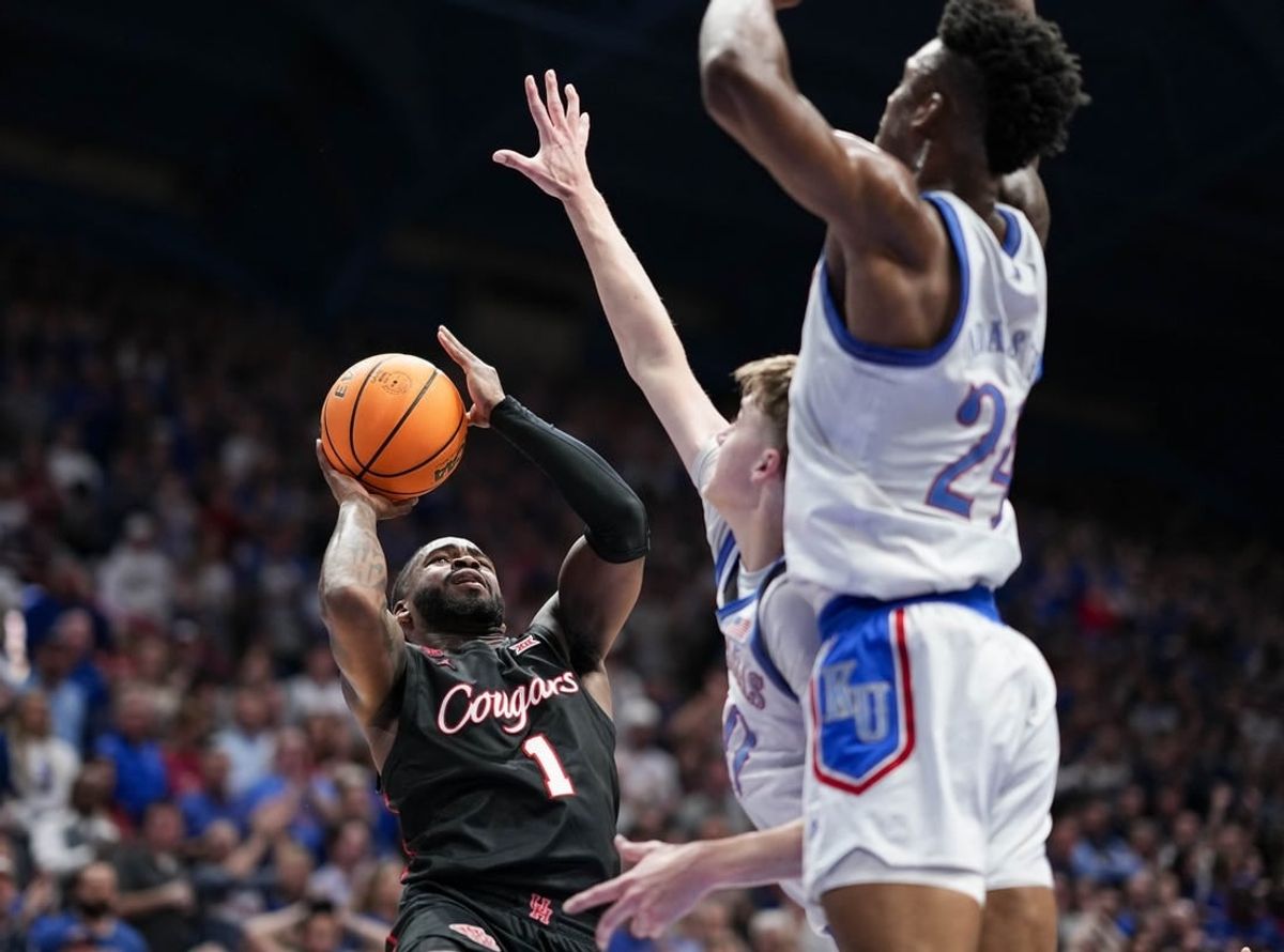 Feb 3, 2024; Lawrence, Kansas, USA; Houston Cougars guard Jamal Shead (1) shoots against Kansas Jayhawks guard Johnny Furphy (10) and forward K.J. Adams Jr. (24) during the first half at Allen Fieldhouse.