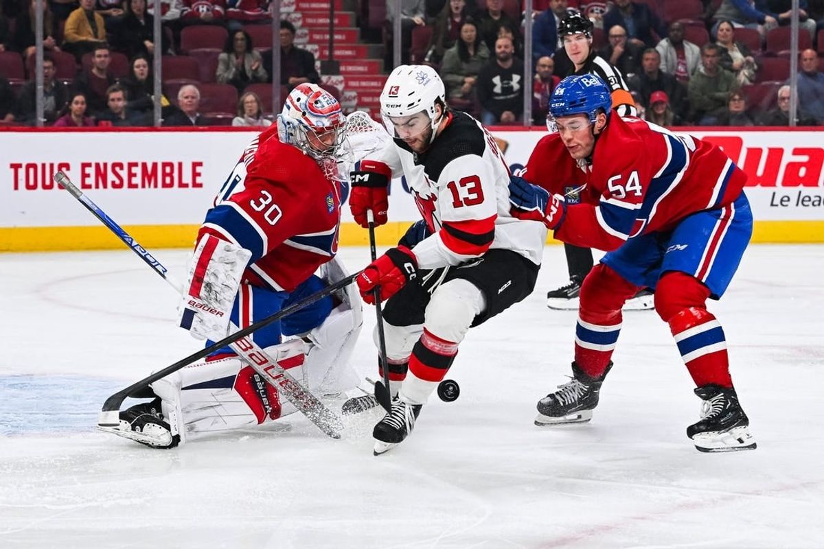Oct 24, 2023; Montreal, Quebec, CAN; Montreal Canadiens goalie Cayden Primeau (30) makes a save against New Jersey Devils center Nico Hischier (13) with Montreal Canadiens defenseman Jordan Harris (54) help during the first period at Bell Centre.
