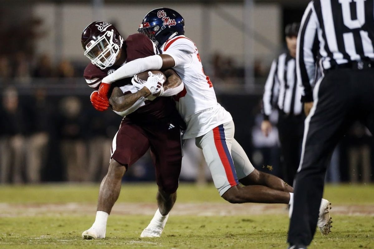 Nov 23, 2023; Starkville, Mississippi, USA; Mississippi State Bulldogs running back Jeffery Pittman (25) runs the ball as Mississippi Rebels linebacker Khari Coleman (23) makes the tackle during the first half at Davis Wade Stadium at Scott Field.