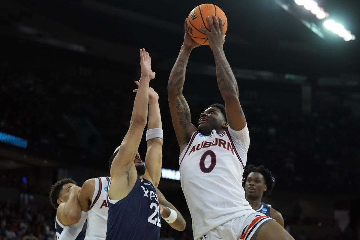 Mar 22, 2024; Spokane, WA, USA; Auburn Tigers guard K.D. Johnson (0) drives to the basket against Yale Bulldogs guard Yassine Gharram (24) during the first half of a game in the first round of the 2024 NCAA Tournament at Spokane Veterans Memorial Arena.