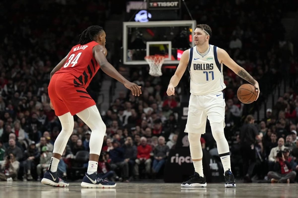 Dec 8, 2023; Portland, Oregon, USA; Dallas Mavericks point guard Luka Doncic (77) brings the ball up court against Portland Trail Blazers forward Jabari Walker (34) during the second half at Moda Center.