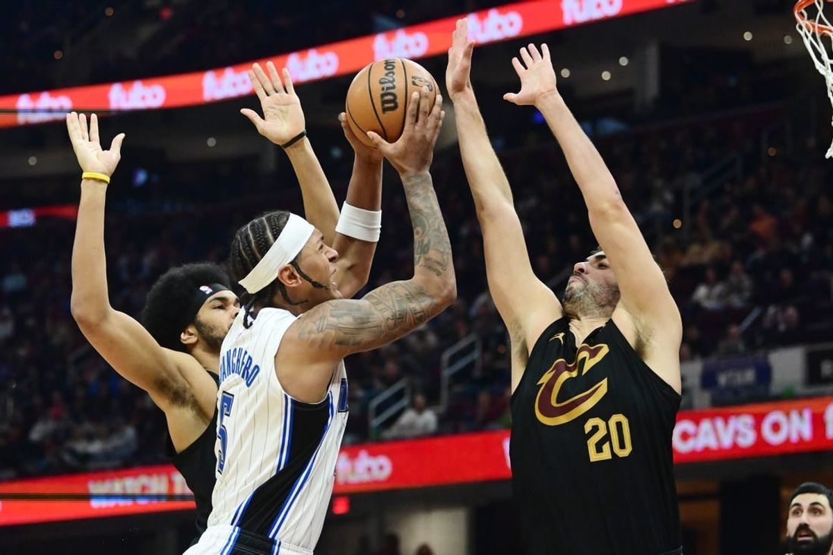 Dec 6, 2023; Cleveland, Ohio, USA; Orlando Magic forward Paolo Banchero (5) drives to the basket between Cleveland Cavaliers center Jarrett Allen (31) and forward Georges Niang (20) during the first half at Rocket Mortgage FieldHouse.