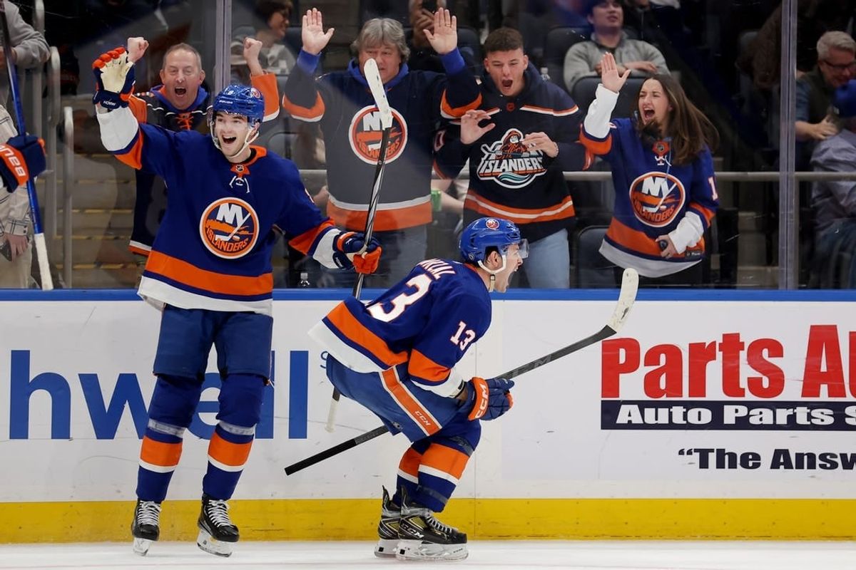 Jan 11, 2024; Elmont, New York, USA; New York Islanders center Mathew Barzal (13) celebrates his game winning goal against the Toronto Maple Leafs with defenseman Noah Dobson (8) during overtime at UBS Arena.