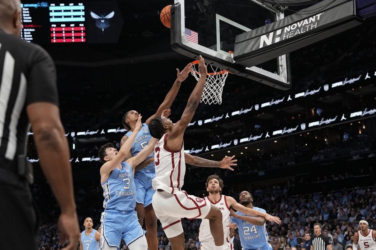 Dec 20, 2023; Charlotte, North Carolina, USA; Oklahoma Sooners guard Otega Oweh (3) has his shot blocked by North Carolina Tar Heels forward Armando Bacot (5) during the first half at Spectrum Center.